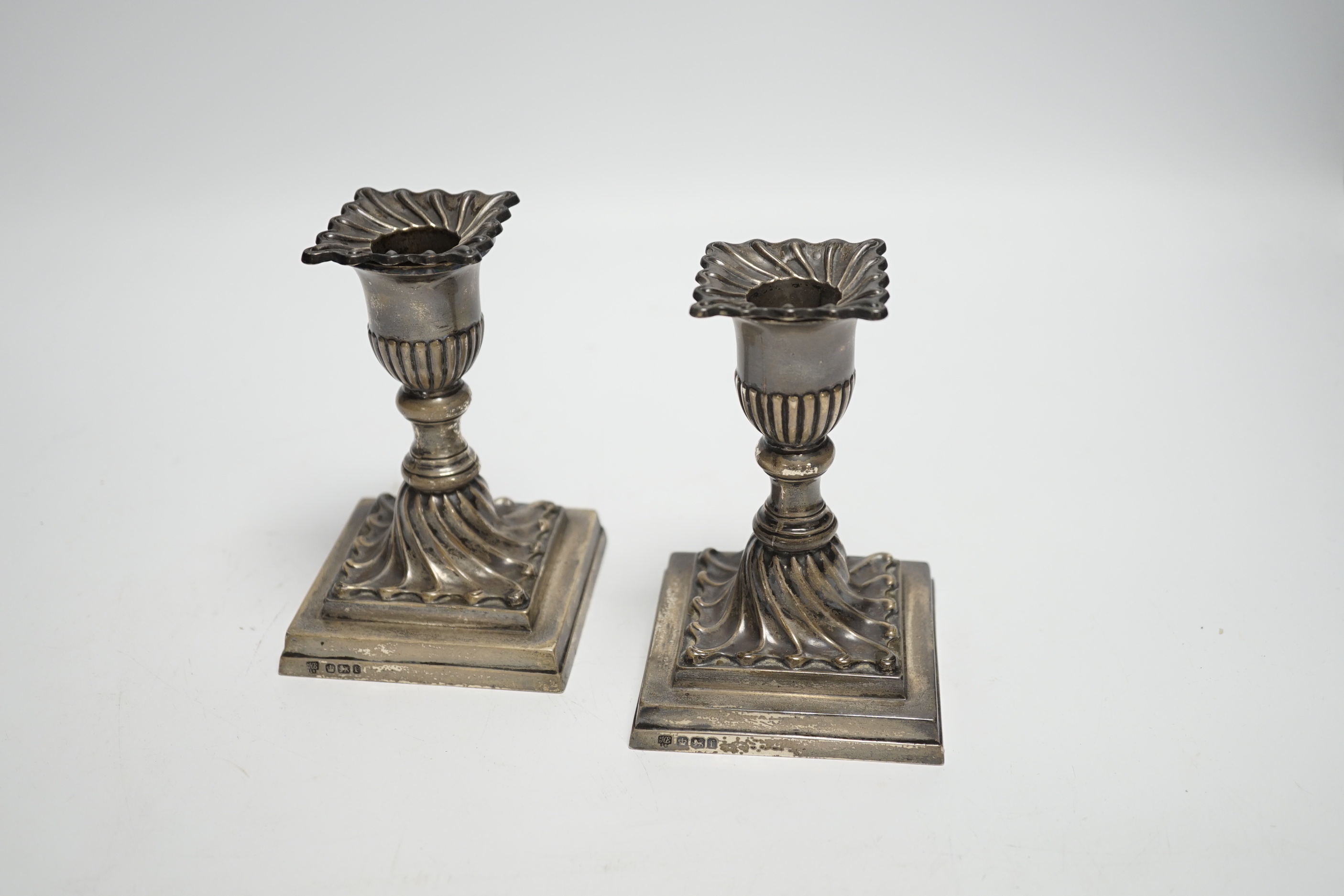 A pair of late Victorian wrythened silver mounted dwarf candlesticks, Hawksworth, Eyre & Co Ltd, Sheffield, 1897, 11.1cm, weighted.